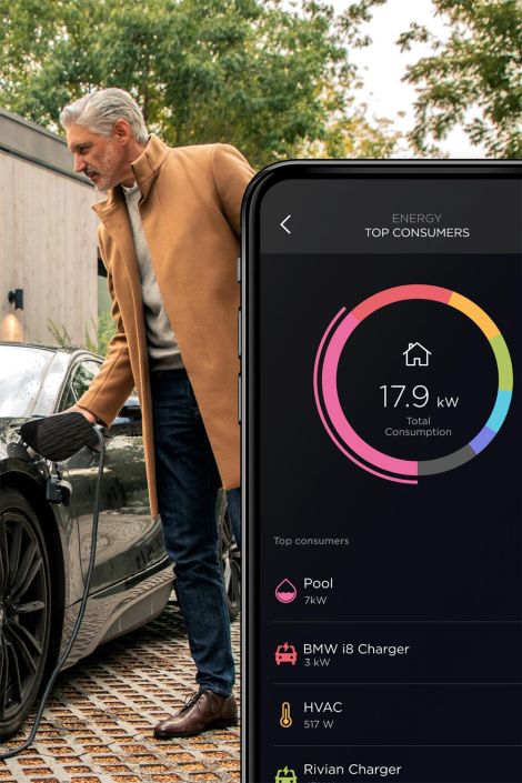 Person charging an electric car while viewing home energy usage on a phone